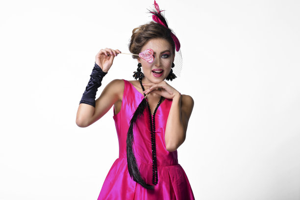 不寻常的穿着照片模特拿着糖果和羽毛。有趣又开朗。时尚摄影。图片下载