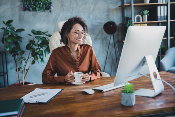 优雅华丽的律师的照片坐在椅子上享受咖啡杯看屏幕看视频工作站办公室室内图片下载
