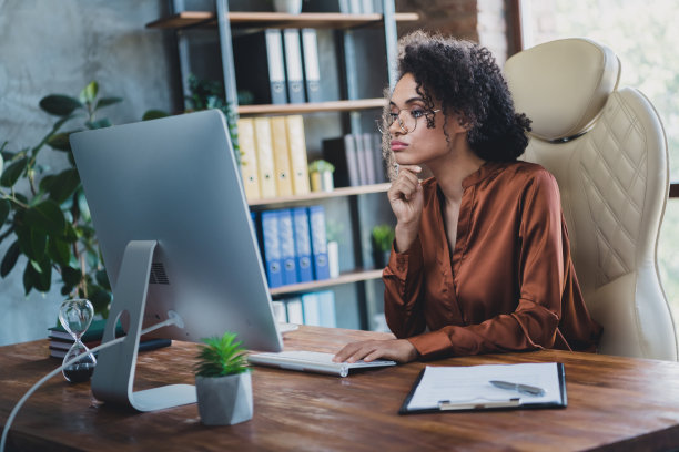头脑聪明的代表照片坐在椅子里，手摸下巴，看视频监控现代商务中心里面图片下载