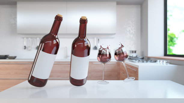一瓶红酒和酒杯漂浮在现代厨房的柜台上图片下载