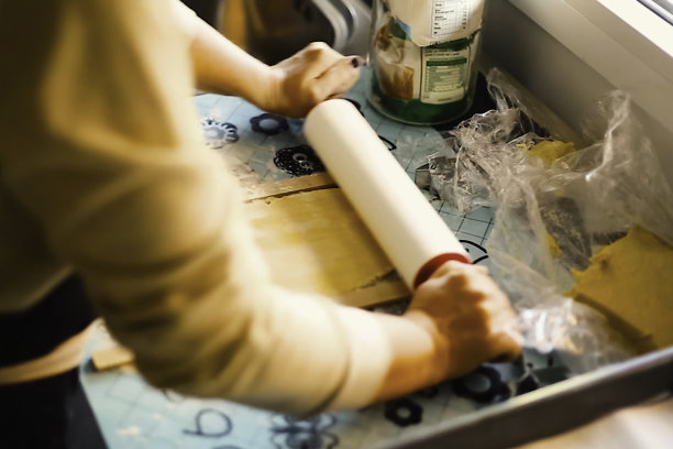 用擀面杖把面团擀开。做面团和烤馅饼。图片下载