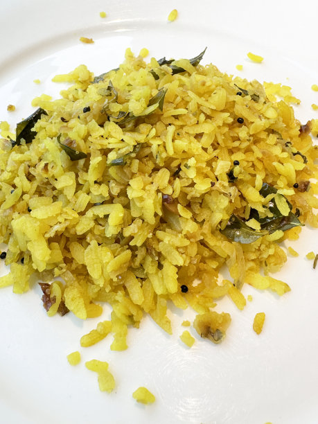 全画幅图片，白色盘子里有印度早餐配方poha(五香碾碎的米饭)，菜有洋葱，青椒，咖喱和香菜叶，花生，芥末和孜然种子，姜黄和柠檬汁，高架视图图片下载
