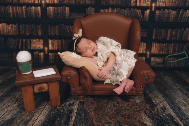 一个新生儿睡在棕色皮椅上图片下载