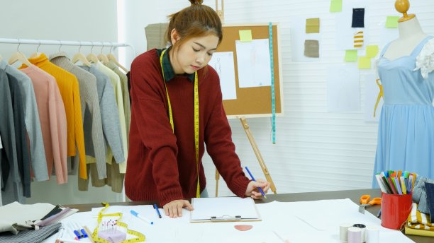 企业家服装设计师在纺织企业设计新的零售服装系列。快乐的职业女性女裁缝，设计织物草图的设计师。年轻设计师时尚理念图片下载