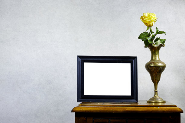 空的相框模型和黄玫瑰花瓶在木桌上靠近垃圾墙，秋天秋天的概念图片下载