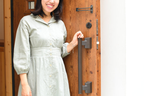 年轻的亚洲女子正在打开住宅楼的前门图片下载