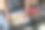 特写照片中，无法辨认的男子在铺着白色羽绒被的双人床上装着灰色的轮式手提箱，俯身去收拾折叠的有领衬衫、整齐折叠的衣服、隔层网眼隔板，重点放在前景上图片下载