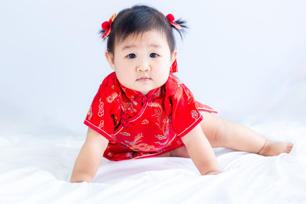 中国新年概念，可爱快乐的小女孩穿着中国服装坐在白色的客厅里。可爱的亚洲宝宝坐在白色的客厅里，中国新年的概念。图片下载