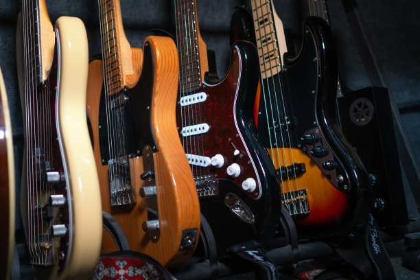 在音乐工作室或商店里，漂亮的吉他靠墙排成一排的特写，选择性聚焦。图片下载