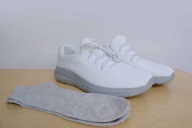 采购产品灰色棉质短袜，白色夏季运动鞋，浅色背景，测试鞋，领带鞋带，鞋子护理和保养，健身和运动，积极的生活方式图片下载