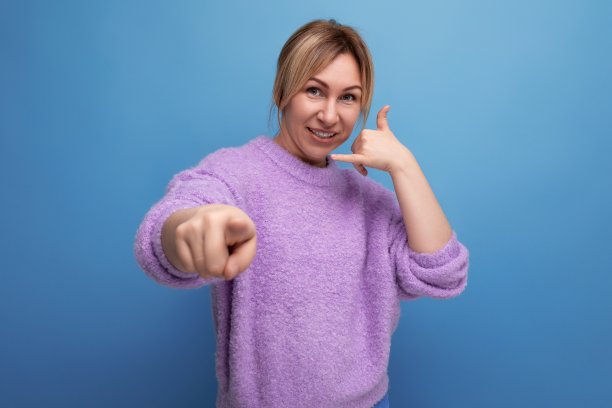 自信、时尚、金发碧眼的年轻女子穿着随意，心情很好，她的手在明亮的背景上伸出来图片下载