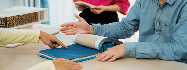 熟练的室内设计师为客户提供窗帘材料。斑叶。图片下载