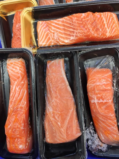 2024年1月3日在印度尼西亚泗水的公共市场，切片红鲑鱼肉与黑色包装图片下载