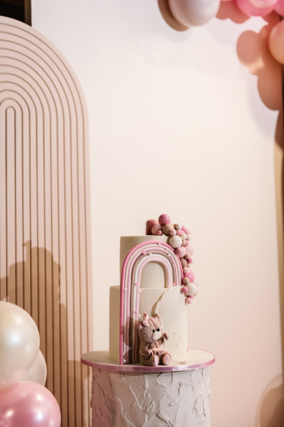 拱门上装饰着粉红色、棕色的气球。蛋糕上装饰着熊的身影、彩虹。时髦的女孩洗礼蛋糕。生日聚会上美味的招待会。照片墙装饰空间或文字的地方。图片下载