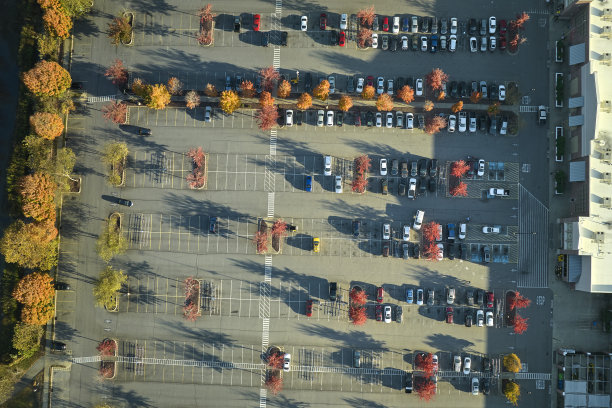鸟瞰图杂货店购物中心和许多五颜六色的汽车停在停车场上的线条和标记的停车位和方向。在商业街广场前停放车辆的地方图片下载
