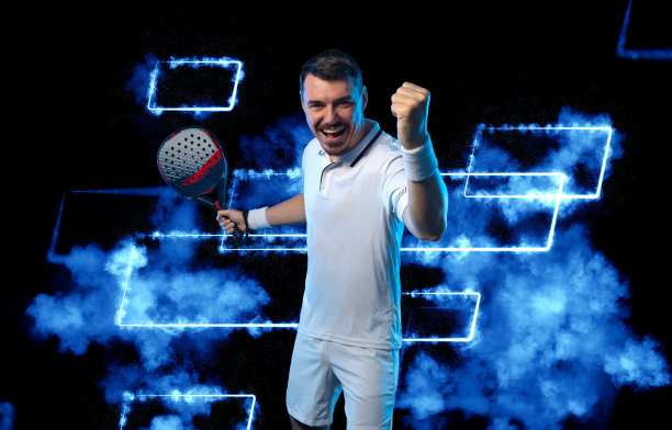 用球拍打网球的运动员。男子运动员与球拍在球场上的霓虹灯颜色。体育的概念。下载一张高质量的照片，用于设计体育应用程序或网站。图片下载