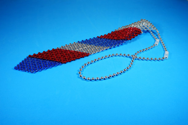 珍珠图案点缀石工作领带孤立在蓝色背景的特写视图图片下载