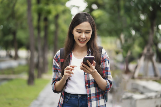 学生们走在校园里，用手机联系朋友图片下载