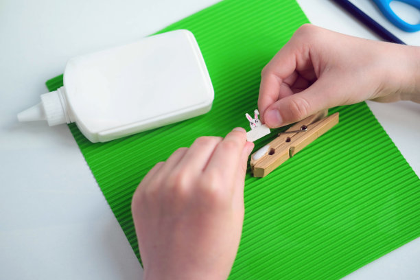 用纸和衣夹做成的儿童工艺品。从绿色的纸一步一步的说明。DIY的概念。一步一步的照片说明。第5步。图片下载