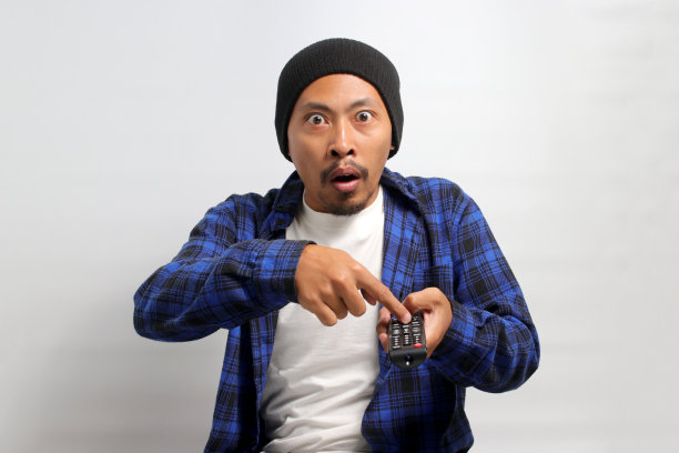 惊讶的年轻亚洲男子在电视上看到令人震惊的新闻图片下载