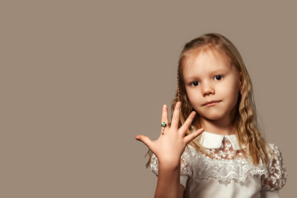 封面女孩模特的肖像，手指上戴着戒指，积极地看着相机。小孩小女孩5岁广告珠宝，摄影棚拍摄。A代概念。复制广告文本空间图片下载