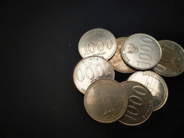 一堆黑色背景的金属印尼盾纸币图片下载