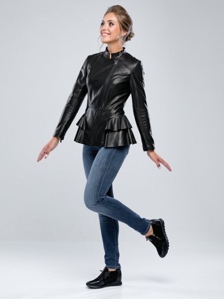 专业模特在白色背景的工作室里为lookbook摆姿势。女人穿皮夹克和牛仔裤。图片下载