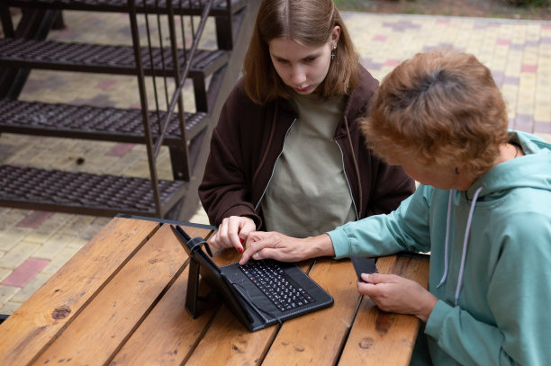 快乐的成熟奶奶用信用卡在笔记本电脑上网购。图片下载