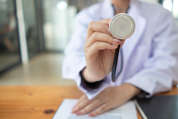 穿制服的女医生拿着听诊器等着给病人检查。图为，一名女医生手持听诊器，准备在医院治疗病人。用于插入医学文本的复制空间图片下载