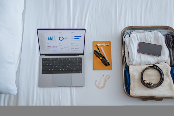 在酒店房间的床上打开行李箱和笔记本电脑(复印空间)图片下载