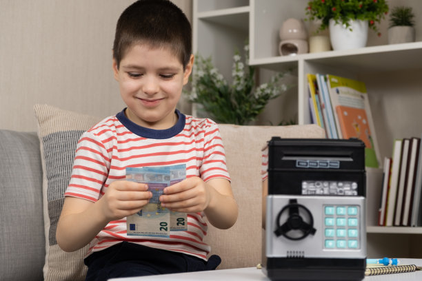一个小男孩正在存钱，手里拿着欧元钞票。儿童理财知识图片下载