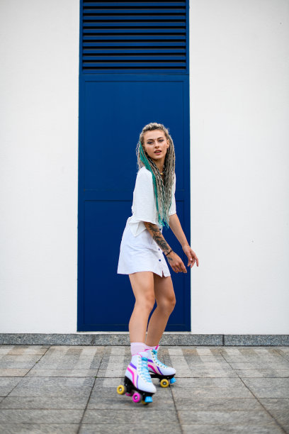 全长照片的妇女与复古轮滑鞋外对白色墙壁的背景图片下载
