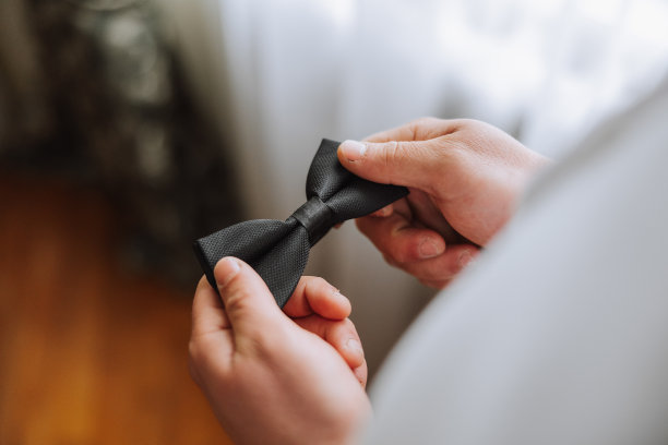 男人手里拿着领带，手的特写照片。新郎正在为婚礼做准备。最后的准备工作。图片下载