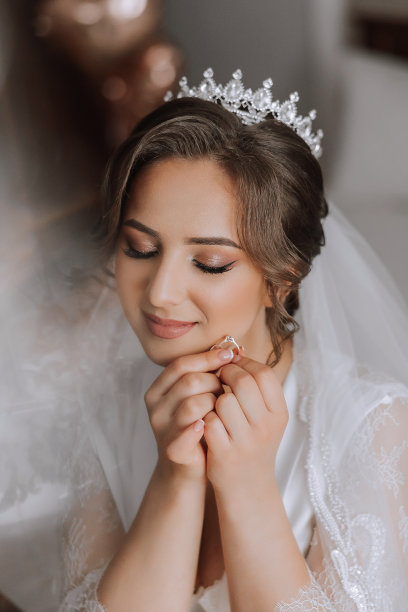 一位美丽的黑发新娘，头上戴着头饰，穿着漂亮的睡袍，准备参加婚礼。特写婚纱照，照片。图片下载