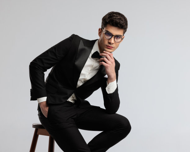 沉思的商人坐在那里，手插在口袋里图片下载