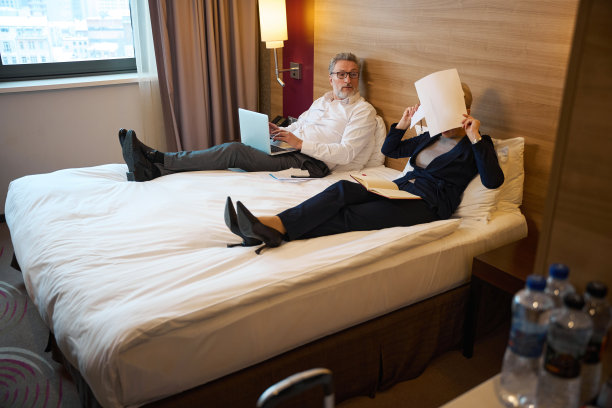 惊讶的商人看着捂着脸的疲惫的女商人图片下载