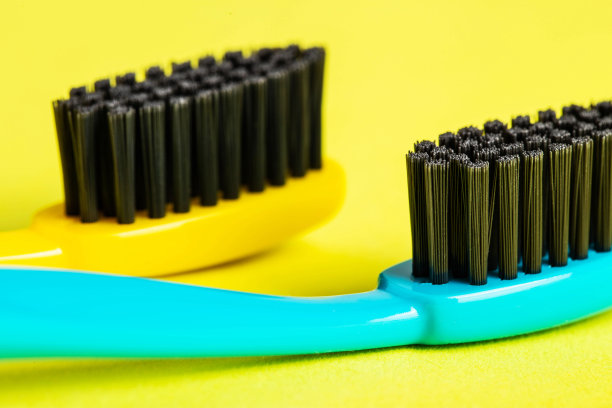 黄色背景上涂有碳涂层的现代牙刷(特写)。中等硬毛的牙刷。口腔护理卫生，宏观，口气清新图片下载