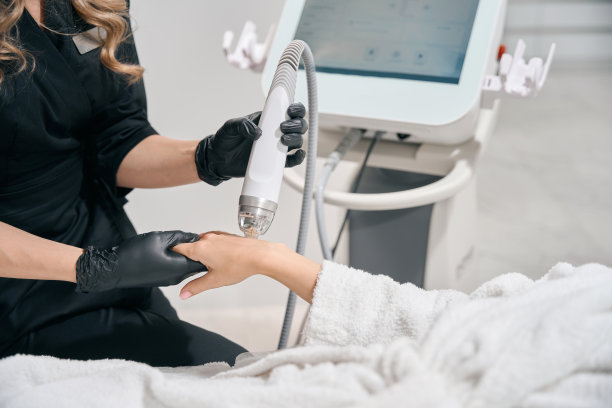 女美容师正在用微针提提女性手臂皮肤的照片图片下载