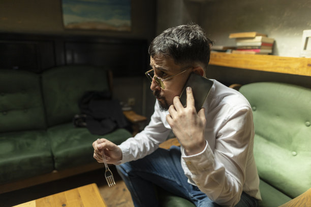 商人在咖啡店用智能手机工作和吃饭。大的对比。库存图片图片下载