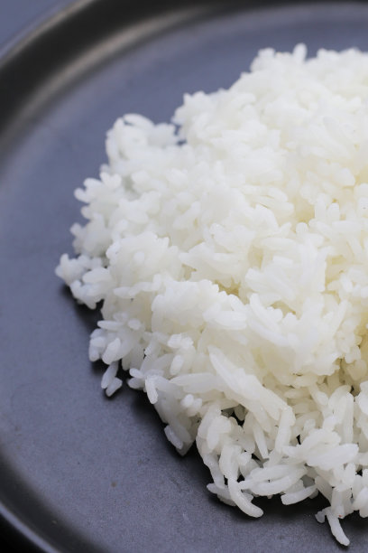 深色背景上煮熟的米饭。图片下载