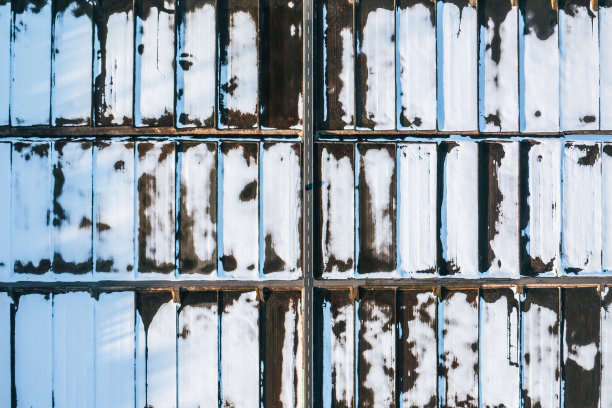 无人机拍摄的照片:在落日的照耀下，一辆汽车的影子行驶在道路上，周围是广阔的冬季稻田图片下载