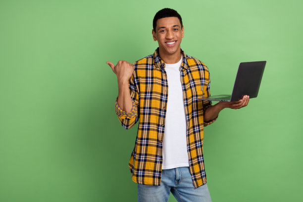 年轻快乐的男子推广电子商务产品的照片，手指网站使用电脑销售服务，绿色背景隔离图片下载