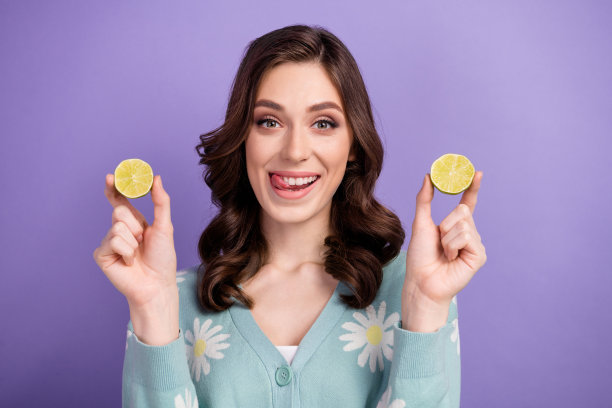 照片时髦狡猾的女人穿着印花开衫舔嘴唇上升石灰片孤立的紫色背景图片下载