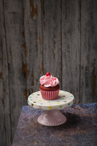 纸杯蛋糕在小陶瓷板与木制底部与复制空间。产品照片。图片下载
