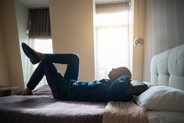 沉思的非裔美国商人躺在床上休息的侧视图图片下载