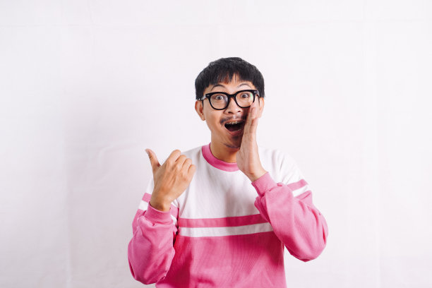 大声喊出来。兴奋的年轻亚洲男子用手靠近嘴宣布。图片下载