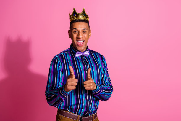 照片上兴奋时髦的家伙穿着金色的条纹衬衫指着你的手指，空白的空间孤立的粉红色背景图片下载