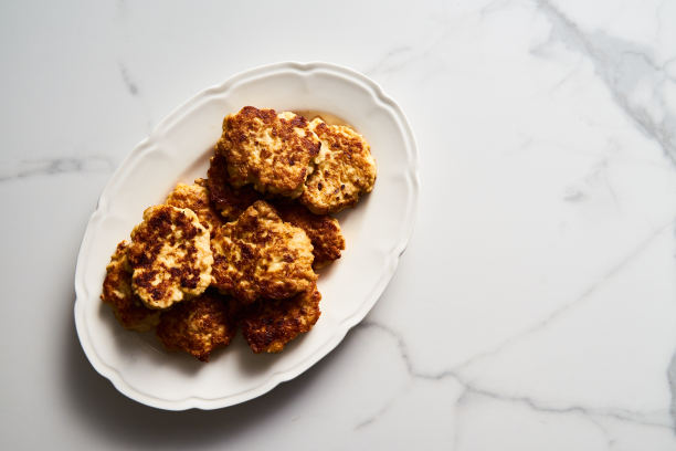 金黄色切碎的鸡肉肉片或配马苏里拉奶酪的肉饼，放在白色的复古盘子里。白色大理石背景上的极简主义食物照片图片下载