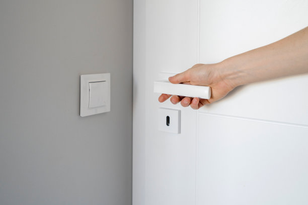 女人用手打开白色金属把手的房间门的特写图片下载