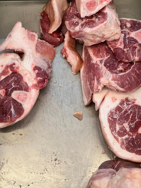 一堆肉放在金属托盘上的照片。图片下载